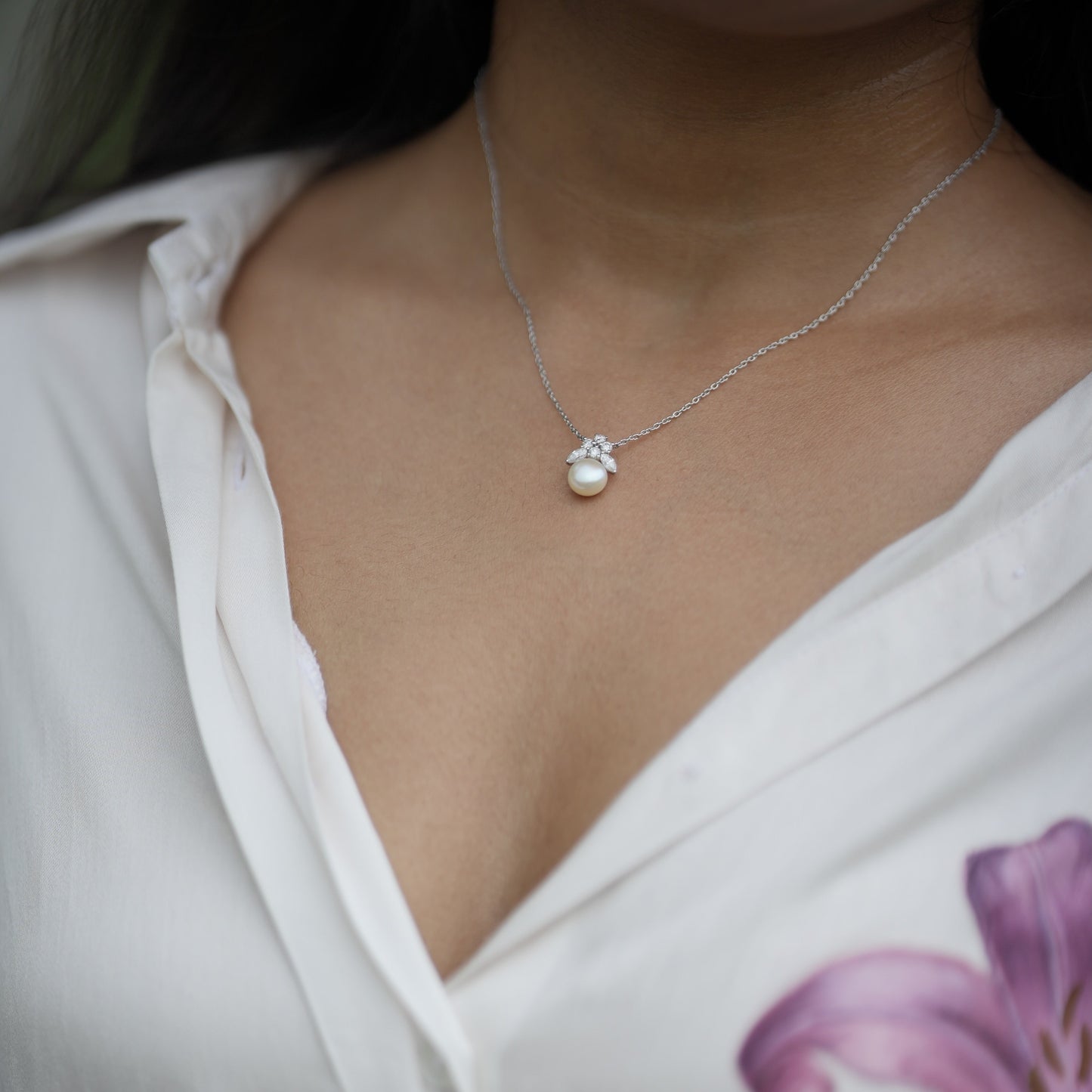 Close-up of a necklace with a pendant with pearls and lab diamonds.
