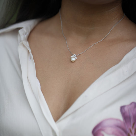 Close-up of a necklace with a pendant with pearls and lab diamonds.